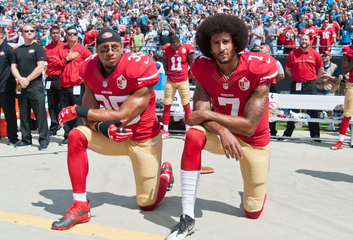 San Francisco quarterback Colin Kapernick and former defensive back Eric Reed kneel during the National Anthem